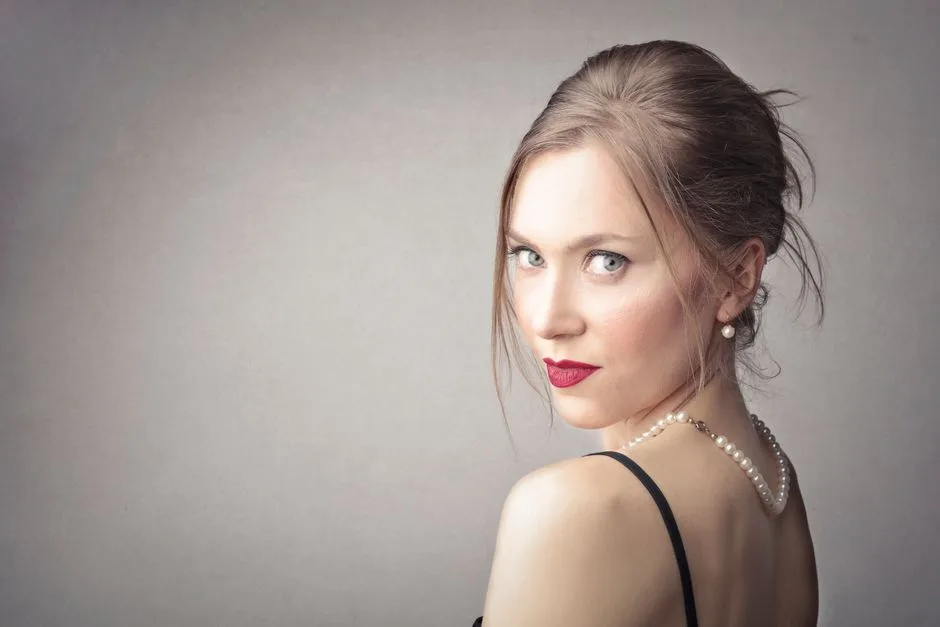 Portrait of a beautiful woman with red lipstick and pearls, exuding elegance.